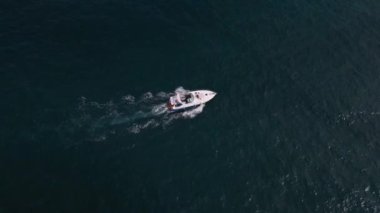 Deniz dalgalarında yarışan bir zevk teknesinin hava aracı görüntüsü hız ve özgürlüğün büyüleyici bir resmini oluşturuyor..