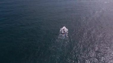 Deniz dalgalarında yarışan bir zevk teknesinin hava aracı görüntüsü hız ve özgürlüğün büyüleyici bir resmini oluşturuyor..