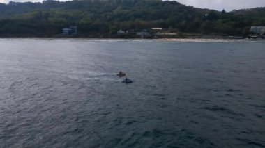 Dalgaların arasından hızla geçen kişisel bir su aracının havadan görünüşü büyüleyici bir iz yaratıyor..