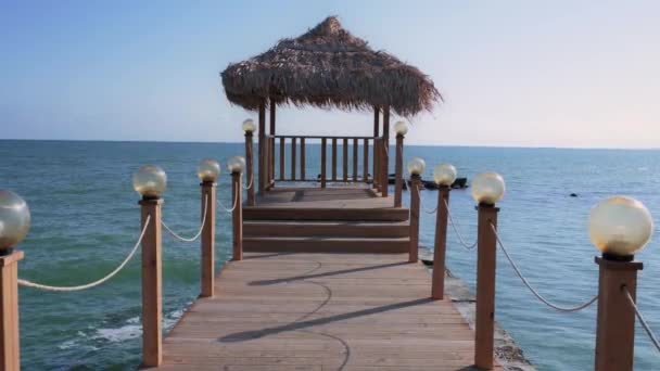 Drewniane Molo Altanką Strzechą Morzu Słoneczny Dzień Wypełnia Miejsce Spokojem — Wideo stockowe
