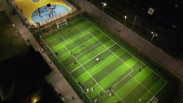 一个晚上有足球和篮球场的运动场的空中俯瞰图 孩子们在那里练习足球和篮球 — 图库视频影像