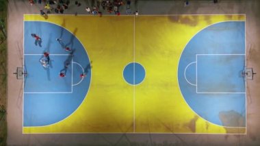 Çocukların basketbol oynadığı bir spor sahasının akşam üstü görüntüsü.