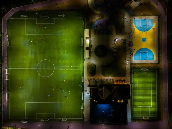 一个晚上有足球和篮球场的运动场的空中俯瞰图 孩子们在那里练习足球和篮球 — 图库照片