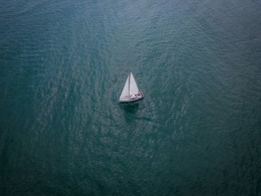 Bir yelkenlinin havadan görünüşü zarif bir şekilde denizin sınırsız dalgalarında süzülüyor..