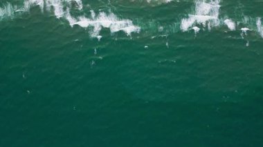 Terkedilmiş kumlu bir sahil üzerinde uçan bir dronun görüntüsü