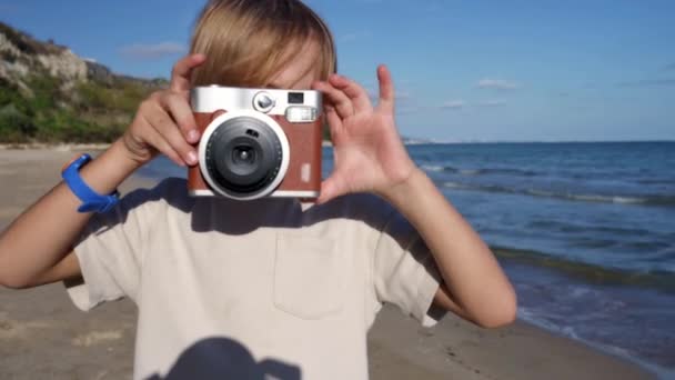 Young Boy Using Instant Camera Take Photograph Beach — Stock Video
