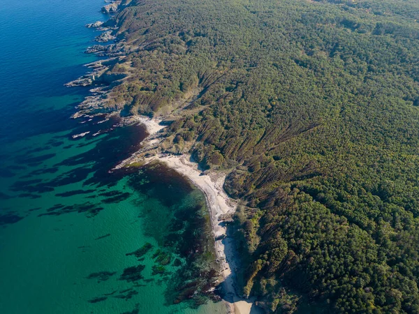 Aerial view of the rocky, wild coast of the Black Sea in Bulgaria, with cliffs, beaches, and green forests.