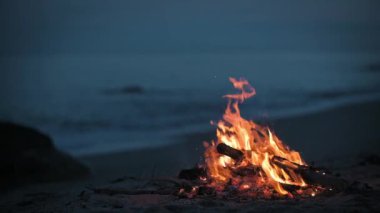 Akşamları deniz kıyısındaki ıssız bir kumsalda bir kamp ateşi yanıyor..