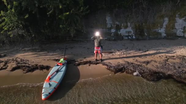 一个人站在海滨的荒野里 用一个信号镜发出求救信号 — 图库视频影像