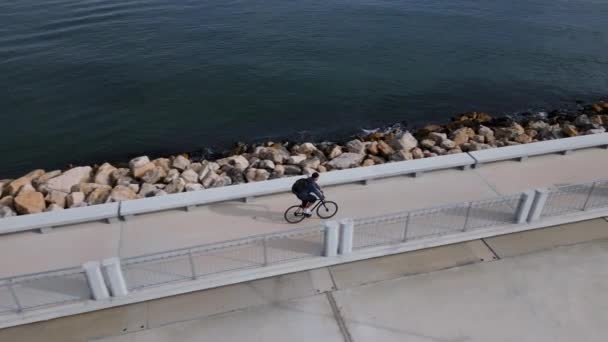 Man Backpack Rides Bicycle Seafront Promenade Seen Flying Drone — Stock Video