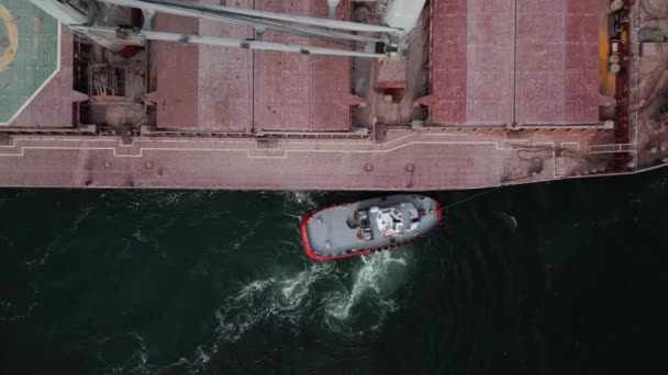 Een Sleepboot Houdt Een Vrachtschip Vaargeul Als Het Haven Verlaat — Stockvideo