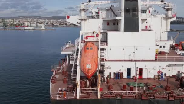 Корм Вантажного Корабля Пливе Порту Моряками Видимим Рятувальним Човном — стокове відео