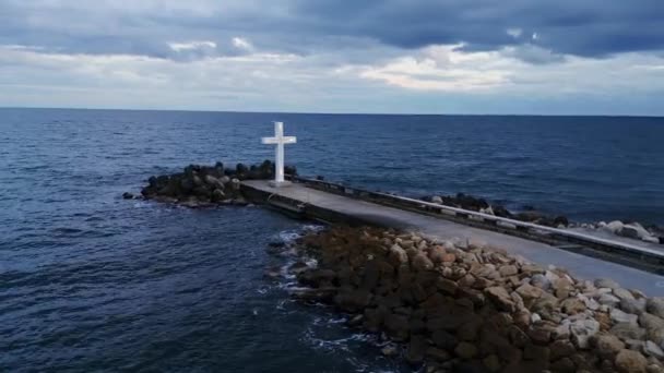 Duży Chrześcijański Krzyż Stoi Skraju Molo Przed Dramatycznym Niebem Morzem — Wideo stockowe