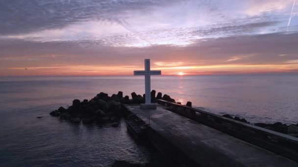 クリスチャンの十字架の周りのフライトは 日の出の朝早くに 大きな十字架は海岸のブレイクウォーターの端に立っています — ストック動画