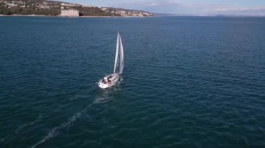 Yelkenli bir yat, rüzgarın sürüklediği denizleri aşan yarışlar düzenliyor. Hava görünümü.