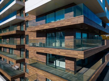 A drone flies along the facade of a modern hotel. Windows and balconies are visible. clipart