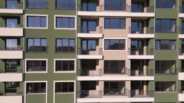 İHA uçuşu, inşaat halindeki modern bir apartmanın ön cephesinde. Etrafı iskelelerle çevrili..