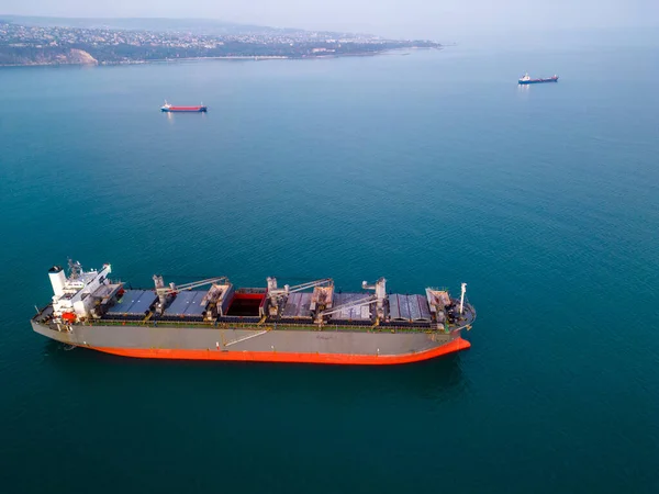 A massive cargo ship wood chips carrier in the sea, aerial view.