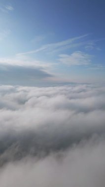 Bir dron kabarık bulutların üzerinde uçar. İnsansız hava aracı bulutların arasında uçuyor, merak ve korku hissi yaratıyor..