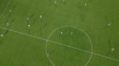 Bir grup oyuncunun sahada tekme, pas ve gol attığı rekabetçi bir futbol maçı izleyin..