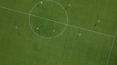 Oyuncular bir maçta yarışırken, bir futbol sahasına kuş bakışı bir göz atın..