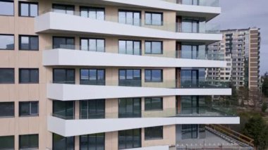 Güneş ışığını yansıtan sayısız pencereyle süslenmiş yüksek bir yapının görüntüsü..