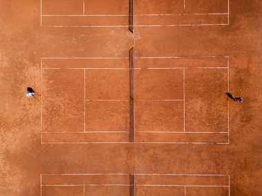İki kişi tenis kortunda aktif olarak tenis oynuyor, topa ağda ileri geri vuruyor. hava görünümü