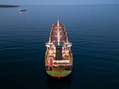 Büyük bir kargo gemisi büyük bir su kütlesi üzerinde zarifçe süzülüyor, büyüklüğünü ve gücünü gösteriyor..