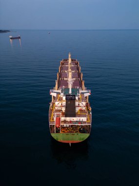 Büyük bir kargo gemisi büyük bir su kütlesi üzerinde zarifçe süzülüyor, büyüklüğünü ve gücünü gösteriyor..