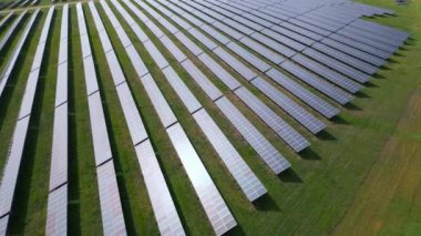 Yaz boyunca bir ormanın yanındaki güneş enerjisi istasyonunun drone görüntüsü. Yenilenebilir enerji, doğayla çarpışır..