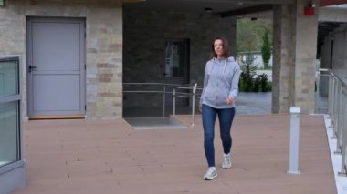 Günlük giysiler içinde genç bir kadın rıhtımda yürüyor..