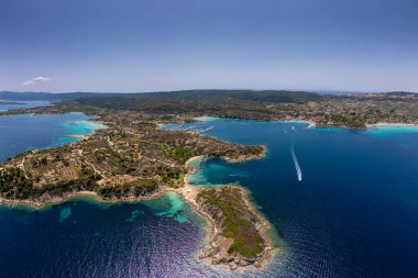 Yunanistan 'ın Sithonia, Diaporos adasının büyüleyici kıyı şeridinin panoramik hava manzarası, turkuaz körfezler, yemyeşil alanlar ve derin mavi denizde dağınık adalar, nefes kesici güzelliği yakalıyor.