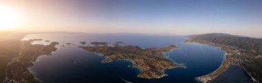 Yunanistan 'ın Sithonia, Diaporos adasının büyüleyici kıyı şeridinin panoramik hava manzarası, turkuaz körfezler, yemyeşil alanlar ve derin mavi denizde dağınık adalar, nefes kesici güzelliği yakalıyor.