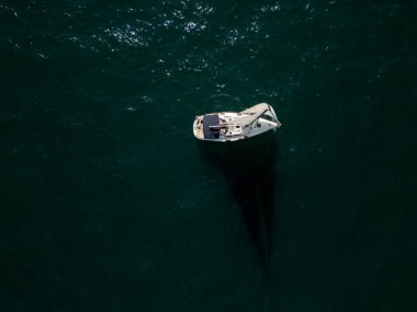 Sakin, mavi sularda, berrak bir gökyüzünün altında süzülen sakin bir yelkenli. Uzak gemiler ve yelkenliler ufukta belirdi. Huzurlu bir deniz manzarası yarattılar..