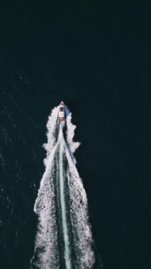 Güçlü bir sürat teknesi açık denizi delip geçiyor ve arkasında çarpıcı bir uyanış bırakıyor. Yukarıdan çekilen sahne, kayığın heyecanını ve uçsuz bucaksız okyanusun güzelliğini gözler önüne seriyor..