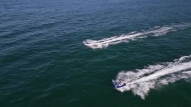 Güçlü bir sürat teknesi açık denizi delip geçiyor ve arkasında çarpıcı bir uyanış bırakıyor. Yukarıdan çekilen sahne, kayığın heyecanını ve uçsuz bucaksız okyanusun güzelliğini gözler önüne seriyor..