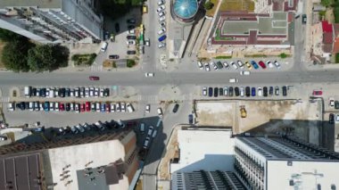 İkametgah binaları, yeşil alanları ve park etmiş araçları olan bir şehir bloğu. Görüntü, yukarıdaki kentsel yaşamın organize yapısını ve yoğunluğunu yakalar..