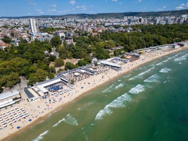 Yazın ortasında Bulgaristan 'ın hareketli Varna sahili ve gezinti alanının havadan görünüşü. Sahne canlı sahil yaşamını, berrak suları ve şehir manzarasını sergiliyor..