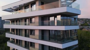 Bej paneller ve beyaz balkonlarla modern bir yerleşim alanının hava aracı görüntüsü, temiz mimari çizgiler ve çağdaş şehir tasarımı vurgulanıyor..