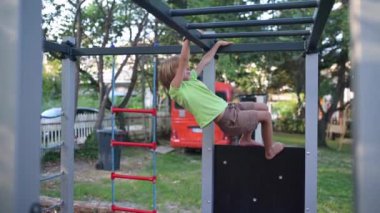 Arka planda turuncu bir minibüsle oyun parkına tırmanan oyuncu bir çocuk. Çocukluk temaları, açık hava aktiviteleri ve macera için mükemmel..