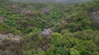 Bulgaristan 'ın Strandzha Ulusal Parkı' ndaki yeşil orman dağlarının üzerinden uçan insansız hava aracının çarpıcı bir görüntüsü, dokunulmamış doğanın ve kayalık arazinin dingin güzelliğini gözler önüne seriyor..
