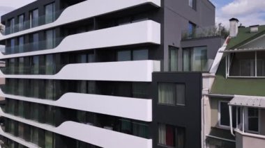 Gösterişli beyaz balkonları ve büyük cam pencereleri olan modern apartman binaları, minimalist mimari ve şehir yaşamını gözler önüne seriyor. Emlak ve tasarım için mükemmel..