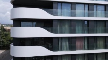 Gösterişli beyaz balkonları ve büyük cam pencereleri olan modern apartman binaları, minimalist mimari ve şehir yaşamını gözler önüne seriyor. Emlak ve tasarım için mükemmel..