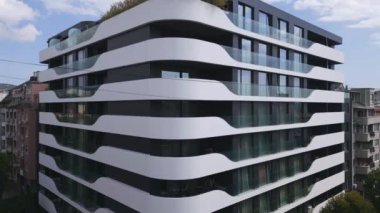 Gösterişli beyaz balkonları ve büyük cam pencereleri olan modern apartman binaları, minimalist mimari ve şehir yaşamını gözler önüne seriyor. Emlak ve tasarım için mükemmel..