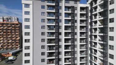 Balkonları ve açık hava alanları olan modern konut binalarının havadan görünüşü. Dairelerin temiz, geometrik tasarımı çağdaş şehir yaşamını ön plana çıkarıyor. İHA ile vurulmuş..