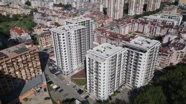 Yüksek konut binaları, renkli mimarisi ve otoparkları olan yoğun nüfuslu bir şehir bölgesinin havadan görüntüsü. Şehir manzarası, kalabalık bir mahallede modern yaşamı gözler önüne seriyor. İHA ile vurulmuş.