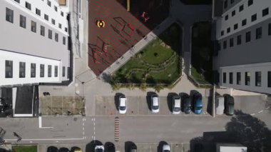 Modern bir konut avlusunun tepeden tırnağa görüntüsü oyun alanı, yeşil alanlar ve bir otopark. Geometrik düzen, yeni bir apartman kompleksinde yaşayan şehirlileri vurguluyor.