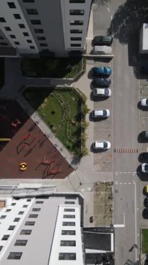 Modern bir konut avlusunun tepeden tırnağa görüntüsü oyun alanı, yeşil alanlar ve bir otopark. Geometrik düzen, yeni bir apartman kompleksinde yaşayan şehirlileri vurguluyor.