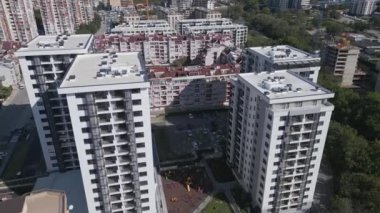 Yüksek konut binaları, renkli mimarisi ve otoparkları olan yoğun nüfuslu bir şehir bölgesinin havadan görüntüsü. Şehir manzarası, kalabalık bir mahallede modern yaşamı gözler önüne seriyor. İHA ile vurulmuş.