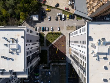 Modern bir konut avlusunun tepeden tırnağa görüntüsü oyun alanı, yeşil alanlar ve bir otopark. Geometrik düzen, yeni bir apartman kompleksinde yaşayan şehirlileri vurguluyor.